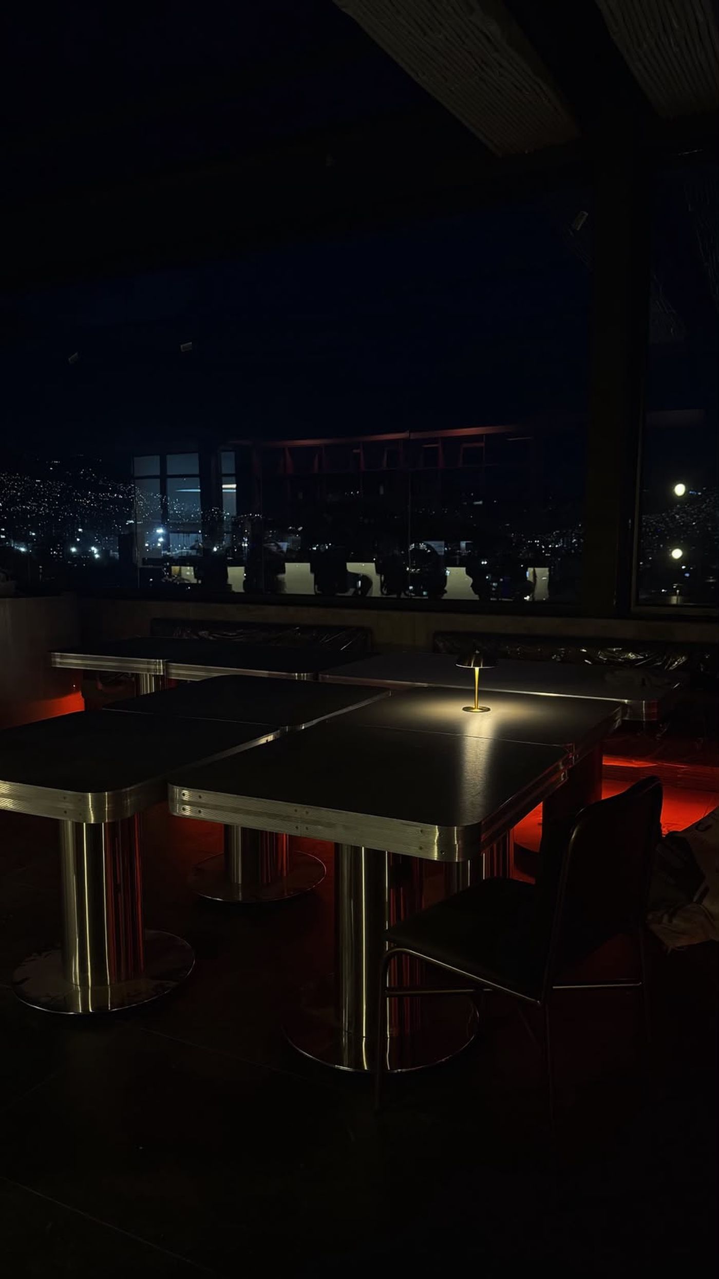 Mesas de Altana Rooftop con vista nocturna de Medellín